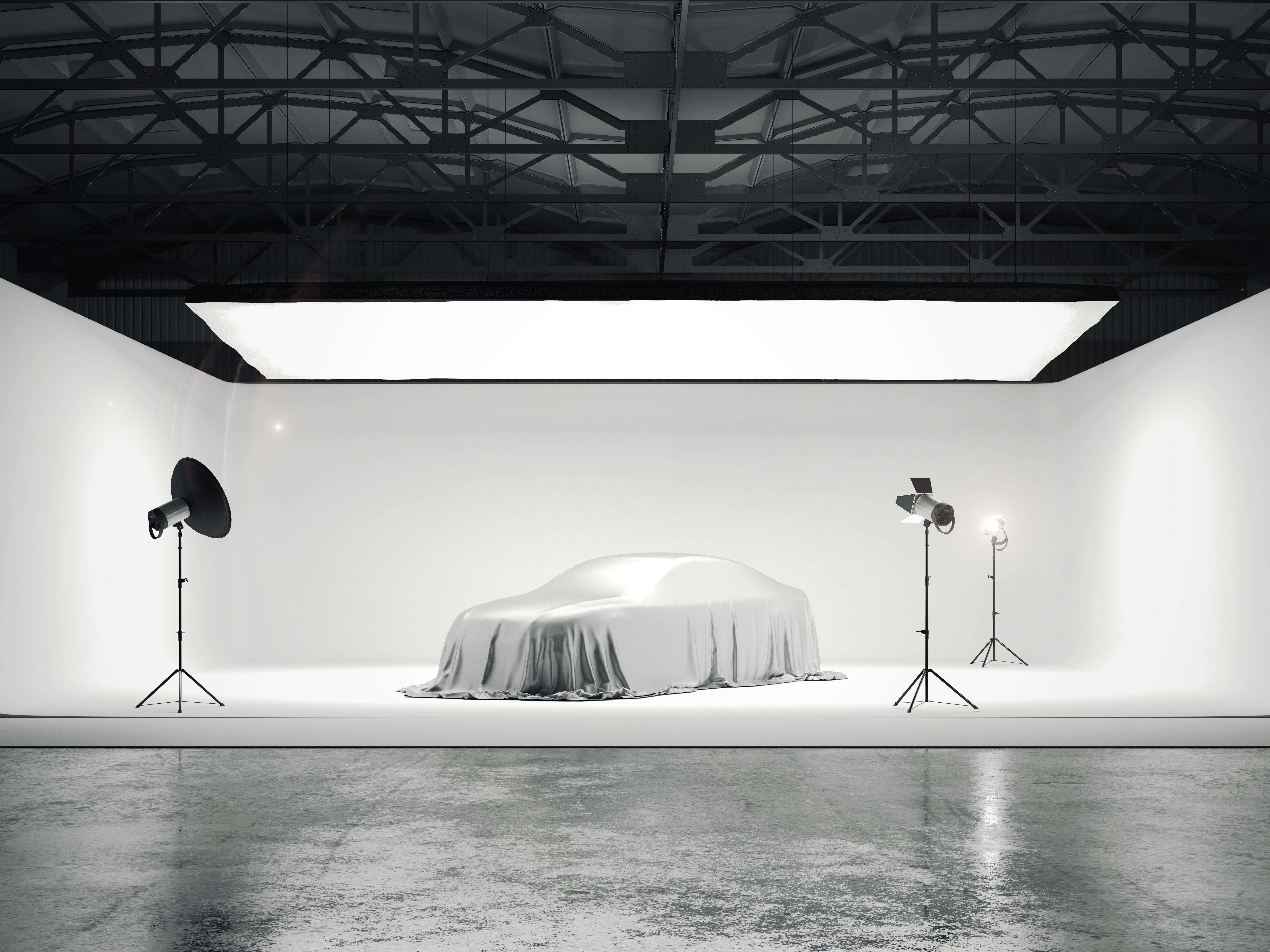 Velké fotografické studio s autem a několika světelnými zdroji